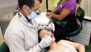Dr. Robert H. DeWitt performing dental checkup